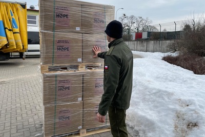 Funkcjonariusz Straży Granicznej przy kartonach ze środkami pomocowymi Funkcjonariusz Straży Granicznej przy kartonach ze środkami pomocowymi