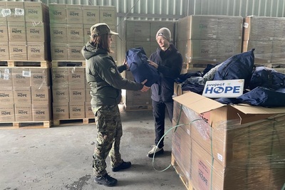 Funkcjonariusz Straży Granicznej przy kartonach ze środkami pomocowymi Funkcjonariusz Straży Granicznej przy kartonach ze środkami pomocowymi