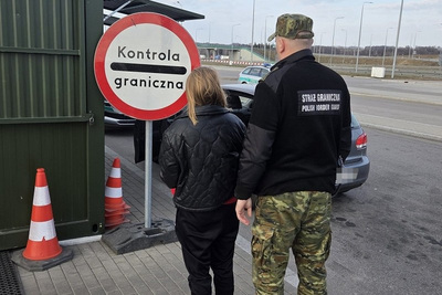 Funkcjonariusze Straży Granicznej podczas wykonywania czynności służbowych w tle znak Kontrola graniczna Funkcjonariusze Straży Granicznej podczas wykonywania czynności służbowych w tle znak Kontrola graniczna