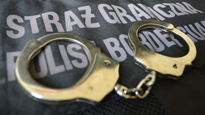 Kajdanki leżą na kamizelce z napisem Straż Graniczna Kajdanki leżą na kamizelce z napisem Straż Graniczna