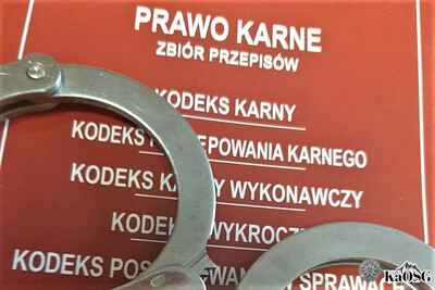 Zdjęcie ilustracyjne przedstawiające kajdanki i zbiór przepisów prawa karnego Zdjęcie ilustracyjne przedstawiające kajdanki i zbiór przepisów prawa karnego