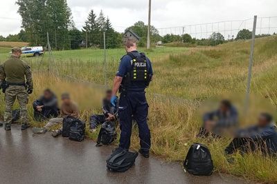 Funkcjonariusz SG i Policji z zatrzymanymi osobami Funkcjonariusz SG i Policji z zatrzymanymi osobami