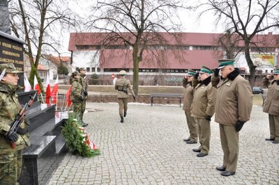 Komendant Główny SG mjr SG Marek Łapiński składa wieniec pod pomnikiem w Kętrzynie 